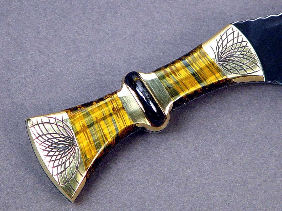 "Nasmyth" fine khukri, obverse side view: 440C high chromium stainless steel blade, hand-engraved brass bolsters, bicolored tiger eye quartz, Australian tiger iron gemstone handle, hand-stamped leather sheath